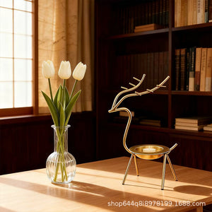 French-chic holiday decorations: deer and elk shaped iron candle holders, golden decorative pieces for restaurant tabletops