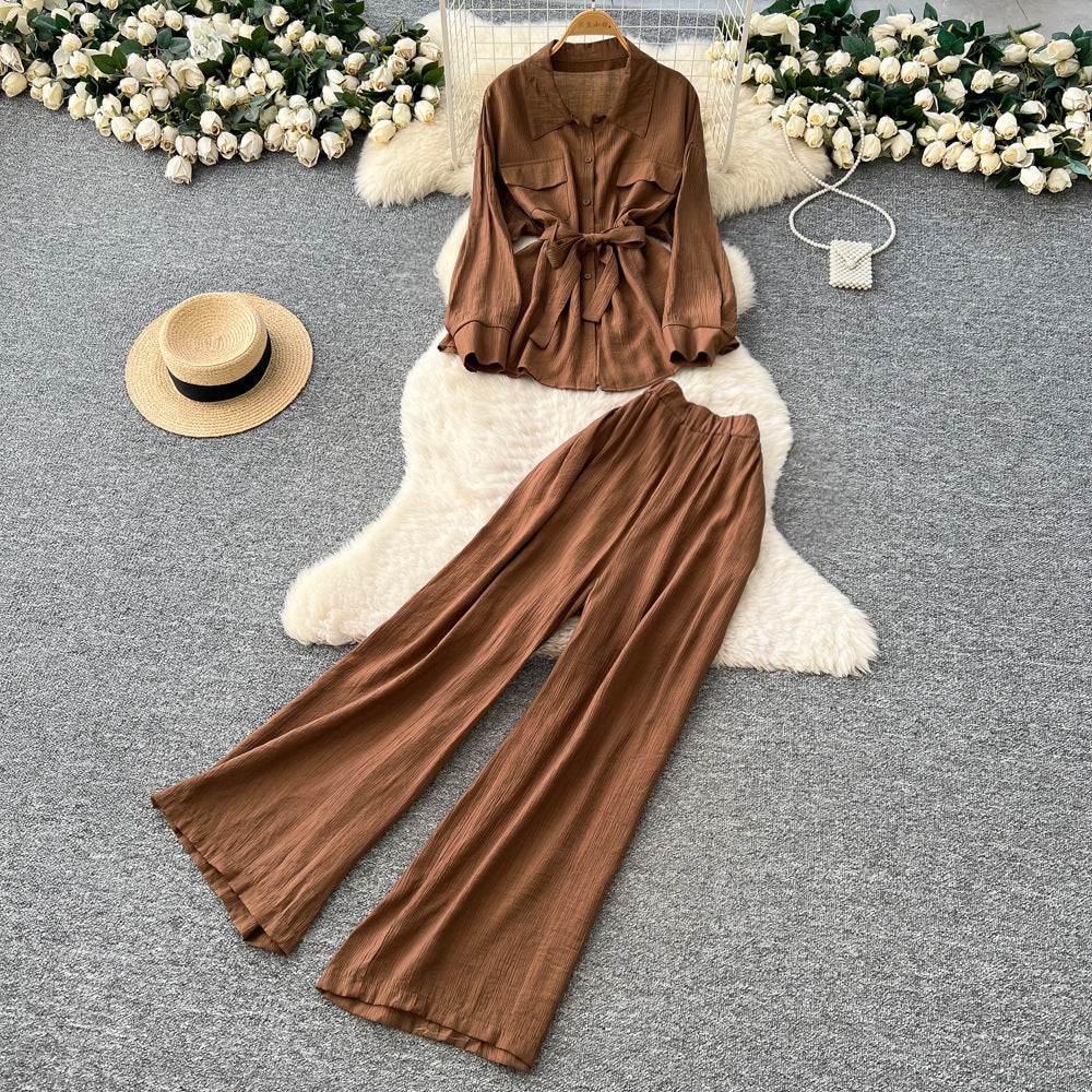 Sophisticated, niche design two-piece set for women: a long-sleeved, tie-waist blouse with a bow detail, paired with high-waisted, wide-leg pants
