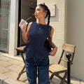Sleeveless, cinched-waist top for women, featuring a ruffled hem, open back with a bow tie closure. a versatile, ready-to-ship piece perfect for everyday wear. ships within 24 hours