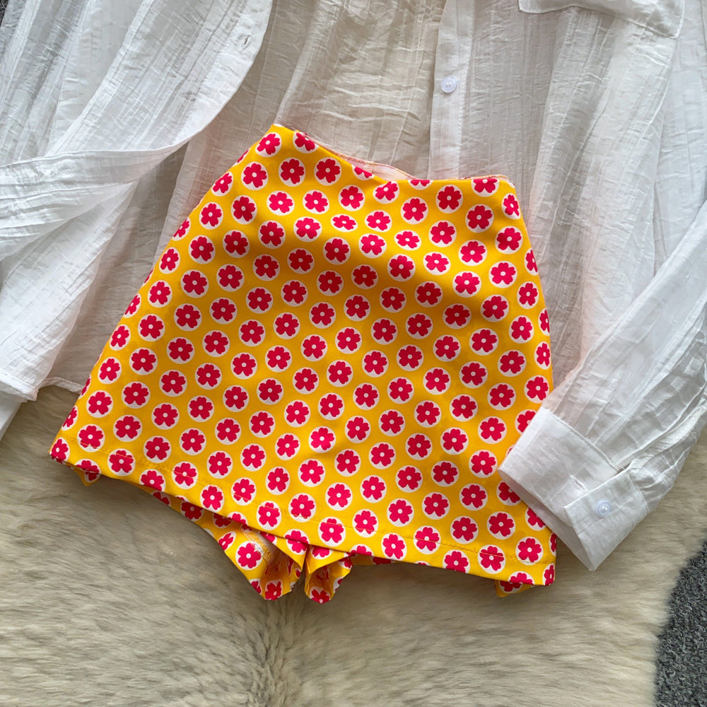 Vacation-ready bikini set for the hot girl summer look: orange cami top, floral print skirt, and sun-protective cardigan – a chic and stylish three-piece outfit