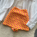 Vacation-ready bikini set for the hot girl summer look: orange cami top, floral print skirt, and sun-protective cardigan – a chic and stylish three-piece outfit