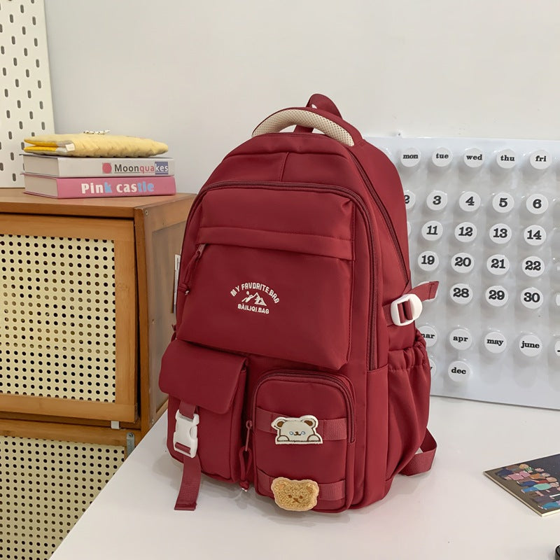 Minimalist korean style fashion casual backpack for high school and college students, featuring cute cartoon badges and large capacity