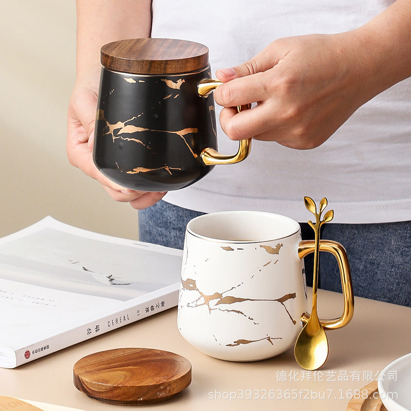 Nordic-inspired ceramic coffee mug, teacup, and saucer set with gold-traced marble pattern and wooden lid