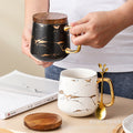 Nordic-inspired ceramic coffee mug, teacup, and saucer set with gold-traced marble pattern and wooden lid