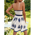 Women's white and blue floral print cami dress with v-neck, cinched waist, and cutout detail – perfect for a fresh and casual summer vacation look