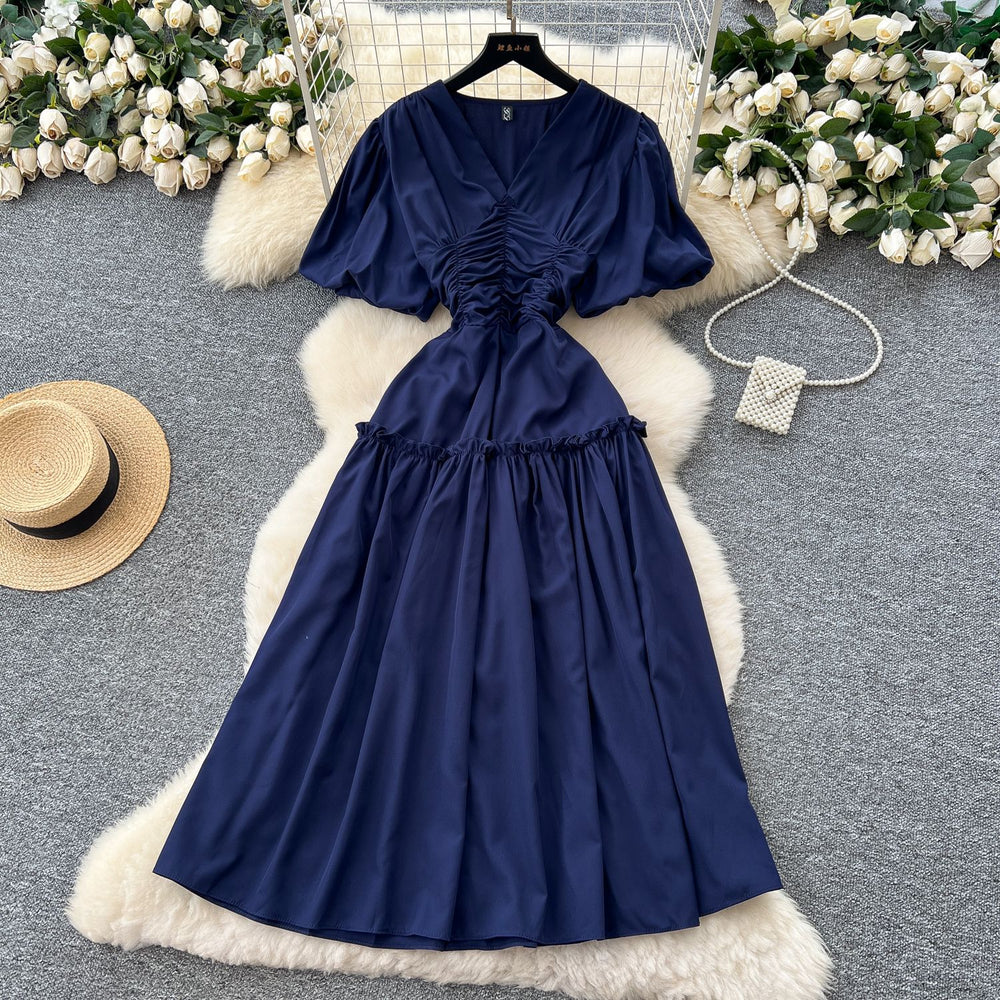 French-inspired, niche v-neck dress with ruched waist, puff sleeves, and a flowy, a-line silhouette. perfect for a slimming and elegant summer look