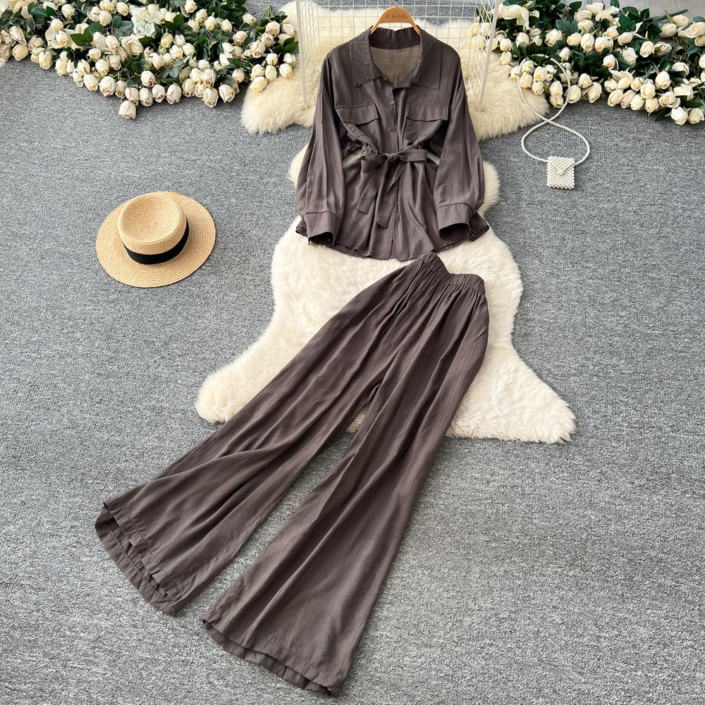 Sophisticated, niche design two-piece set for women: a long-sleeved, tie-waist blouse with a bow detail, paired with high-waisted, wide-leg pants