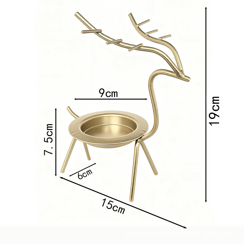 French-chic holiday decorations: deer and elk shaped iron candle holders, golden decorative pieces for restaurant tabletops