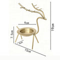 French-chic holiday decorations: deer and elk shaped iron candle holders, golden decorative pieces for restaurant tabletops
