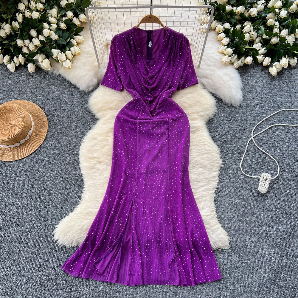 Elegant and alluring, this high-end, figure-hugging, mid-length mermaid gown features a plunging neckline, short sleeves, hot-fix rhinestone embellishments, and a daring slit. perfect for the sophisticated woman