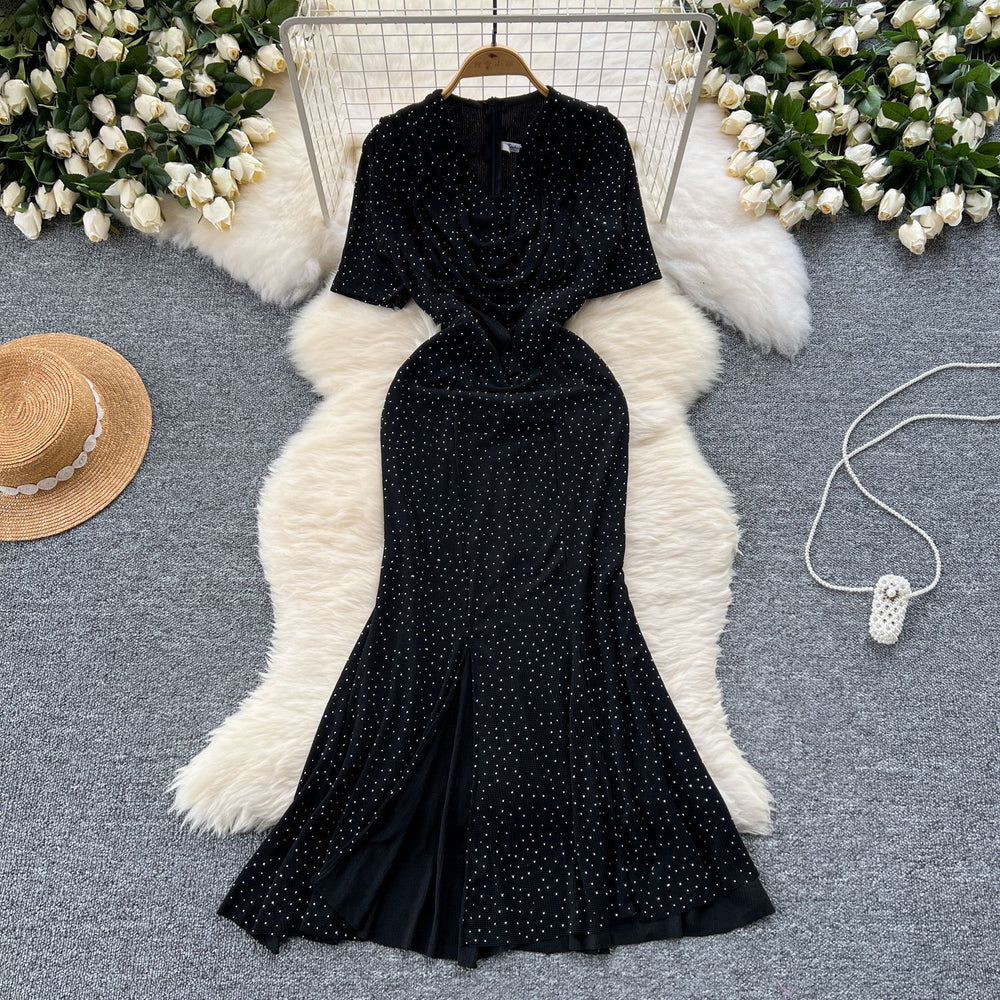 Elegant and alluring, this high-end, figure-hugging, mid-length mermaid gown features a plunging neckline, short sleeves, hot-fix rhinestone embellishments, and a daring slit. perfect for the sophisticated woman