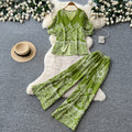 Vacation-ready green floral print two-piece set for women. summer v-neck, slimming wide-leg pants, perfect for both work and play. a stylish and chic outfit