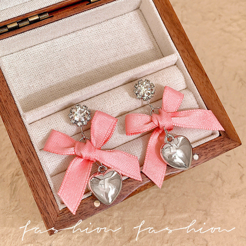 "instagram-worthy, 'rich girl' style pink bow and heart pendant earrings – unique, sweet, and perfect for vacation. wholesale available."