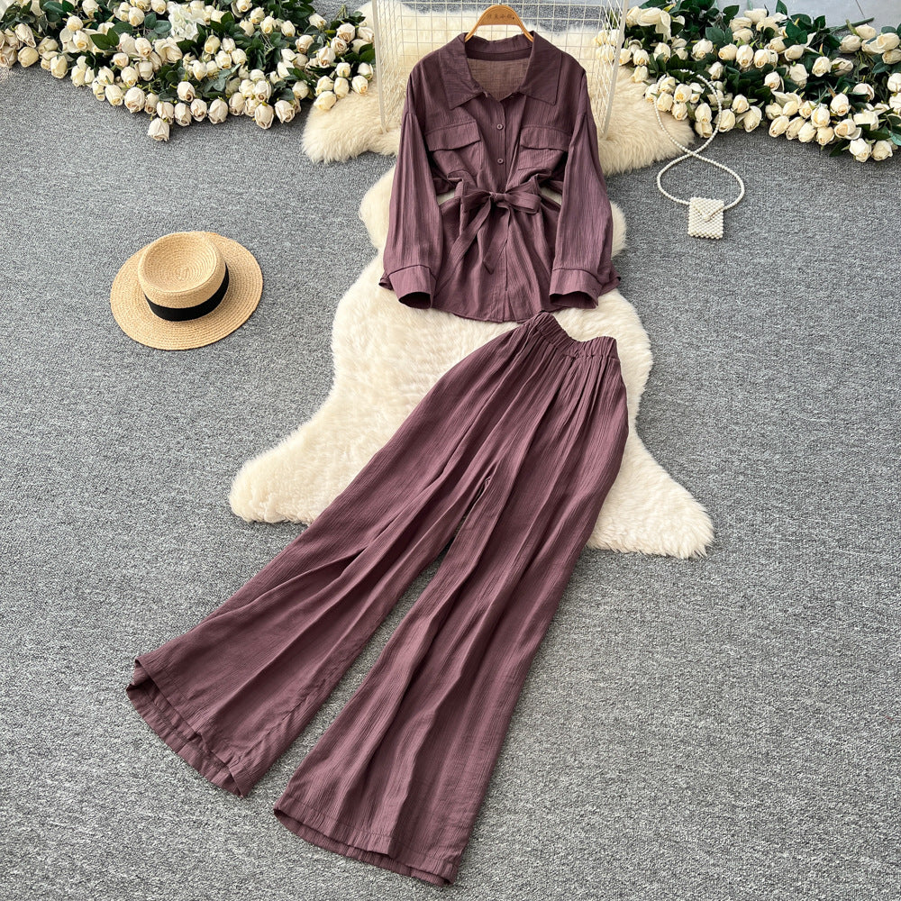 Sophisticated, niche design two-piece set for women: a long-sleeved, tie-waist blouse with a bow detail, paired with high-waisted, wide-leg pants