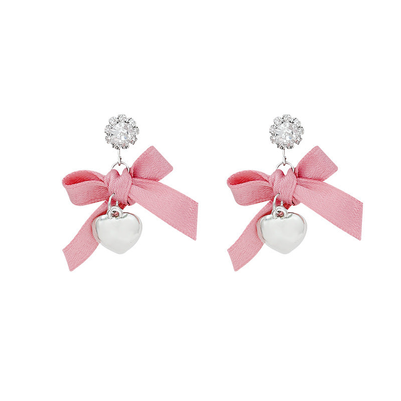 "instagram-worthy, 'rich girl' style pink bow and heart pendant earrings – unique, sweet, and perfect for vacation. wholesale available."
