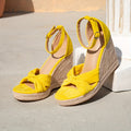 Yellow faux suede wedge sandals with braided rope platform, bow accent, and ankle strap – stylish women's footwear for vacation
