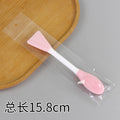 Pink double-ended facial cleansing brush spatula-shaped