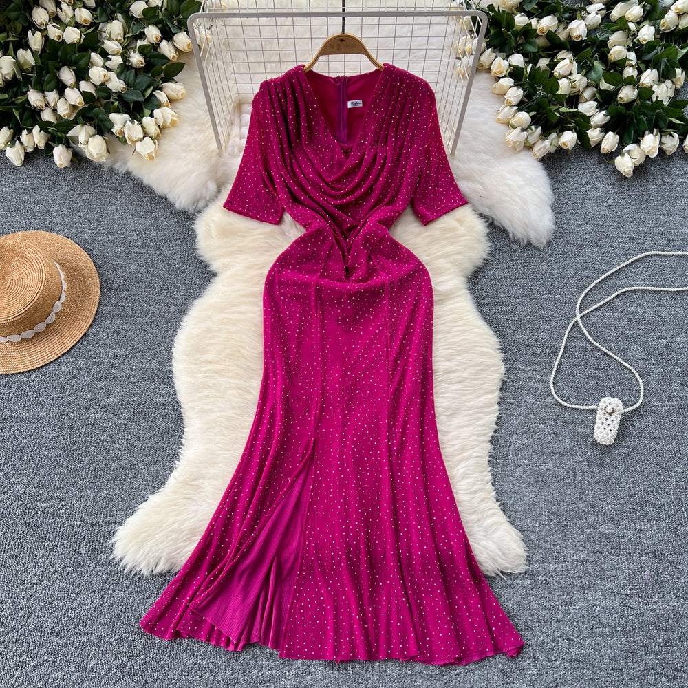 Elegant and alluring, this high-end, figure-hugging, mid-length mermaid gown features a plunging neckline, short sleeves, hot-fix rhinestone embellishments, and a daring slit. perfect for the sophisticated woman