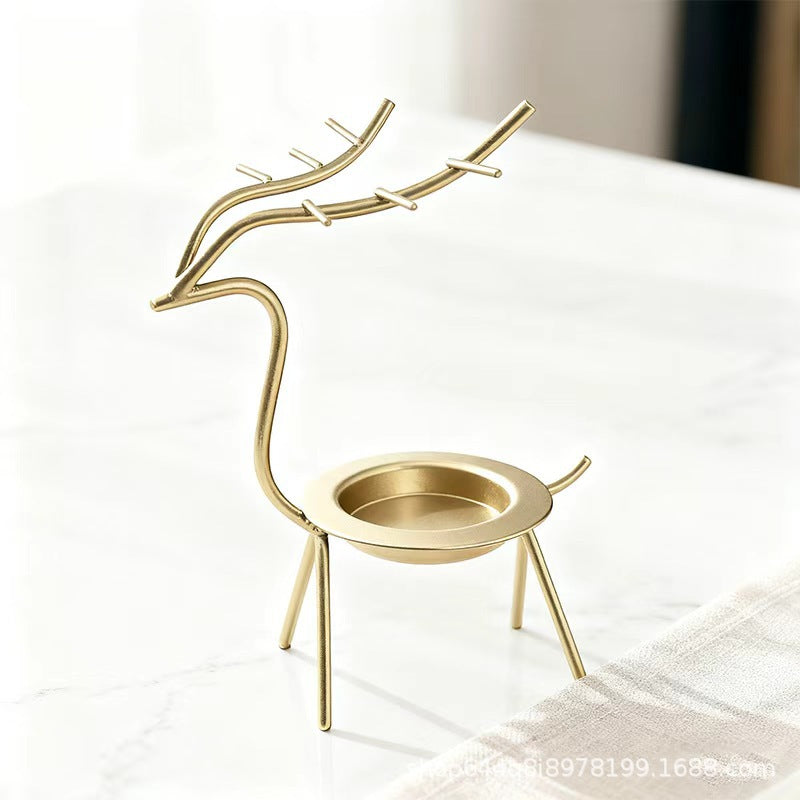 French-chic holiday decorations: deer and elk shaped iron candle holders, golden decorative pieces for restaurant tabletops
