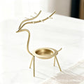 French-chic holiday decorations: deer and elk shaped iron candle holders, golden decorative pieces for restaurant tabletops