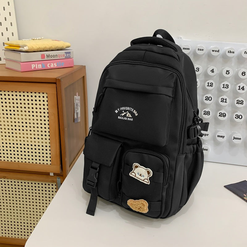 Minimalist korean style fashion casual backpack for high school and college students, featuring cute cartoon badges and large capacity