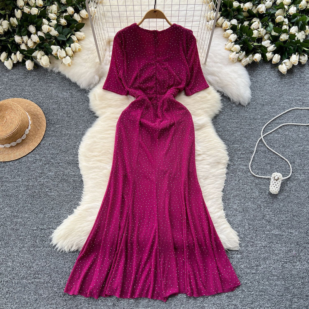 Elegant and alluring, this high-end, figure-hugging, mid-length mermaid gown features a plunging neckline, short sleeves, hot-fix rhinestone embellishments, and a daring slit. perfect for the sophisticated woman
