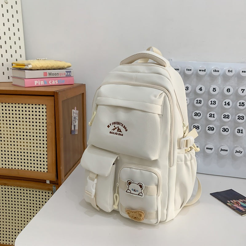 Minimalist korean style fashion casual backpack for high school and college students, featuring cute cartoon badges and large capacity