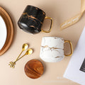 Nordic-inspired ceramic coffee mug, teacup, and saucer set with gold-traced marble pattern and wooden lid
