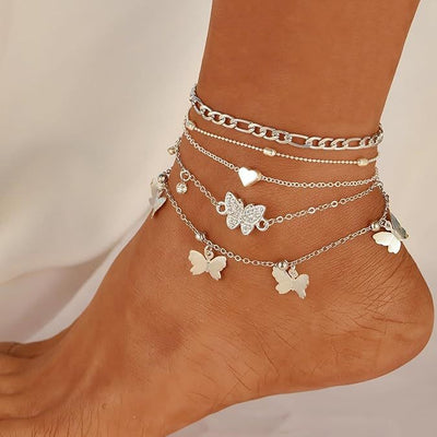 "instagram-worthy, understated luxury anklet set featuring butterfly, shell, and seed beads. available in gold and white gold."