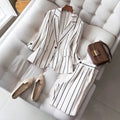 elegant vertical striped commute set: notch lapel blazer with cinched waist, paired with high-waisted, drapey wide-leg trousers for women