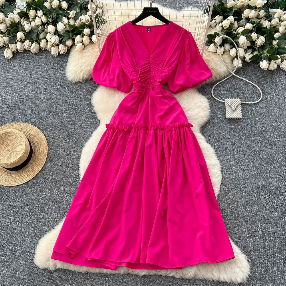 French-inspired, niche v-neck dress with ruched waist, puff sleeves, and a flowy, a-line silhouette. perfect for a slimming and elegant summer look
