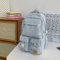 Minimalist korean style fashion casual backpack for high school and college students, featuring cute cartoon badges and large capacity