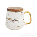 Nordic-inspired ceramic coffee mug, teacup, and saucer set with gold-traced marble pattern and wooden lid