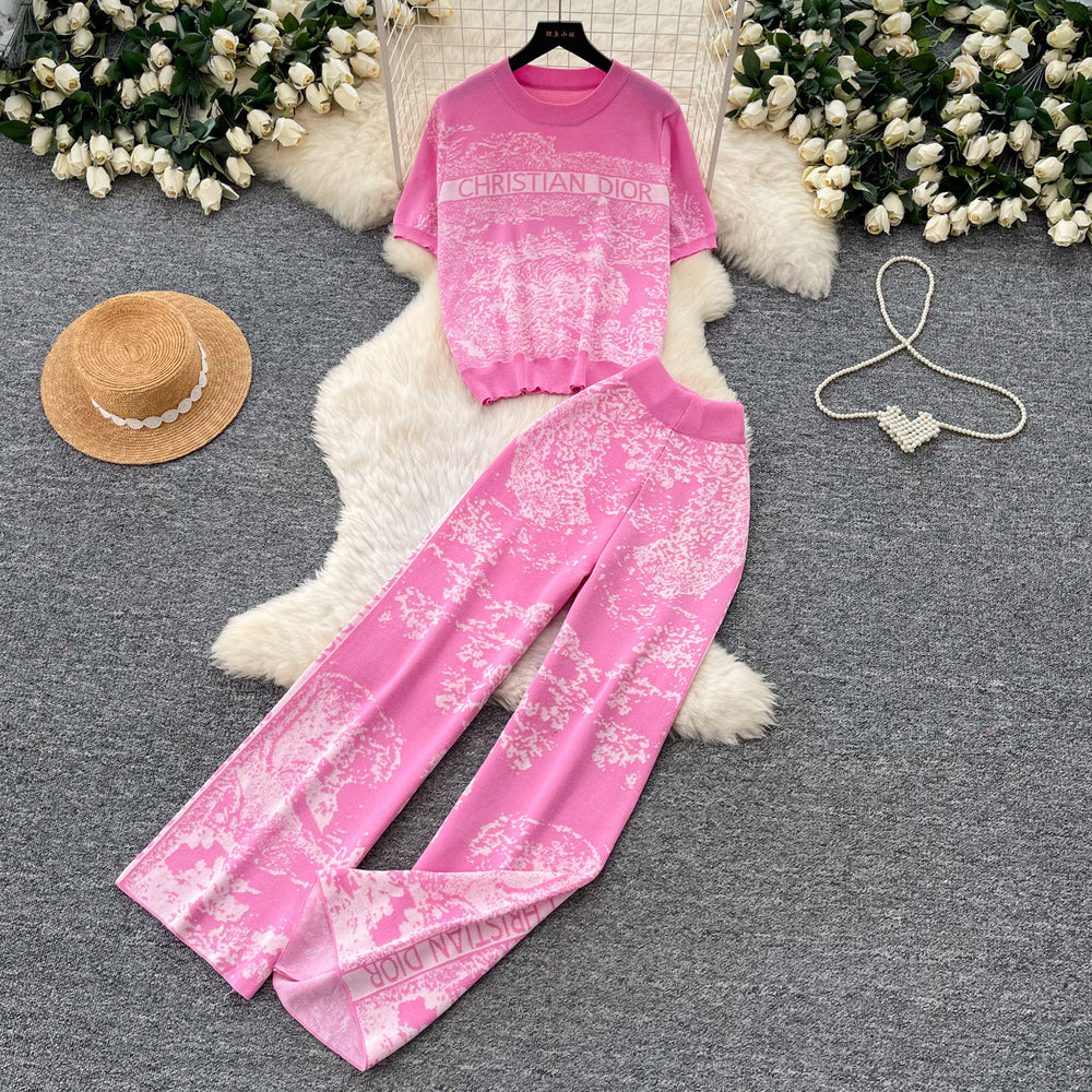 Vacation-ready pink floral print letter print casual two-piece set for women, featuring a summer short-sleeved top and high-waisted wide-leg pants. a stylish and versatile outfit perfect for both work and play