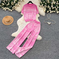 Vacation-ready pink floral print letter print casual two-piece set for women, featuring a summer short-sleeved top and high-waisted wide-leg pants. a stylish and versatile outfit perfect for both work and play