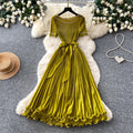 Sophisticated and elegant green pleated dress for women. short-sleeved, waist-cinching, pleated maxi dress, perfect for the office or a sophisticated socialite look