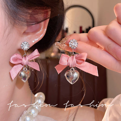 "instagram-worthy, 'rich girl' style pink bow and heart pendant earrings – unique, sweet, and perfect for vacation. wholesale available."
