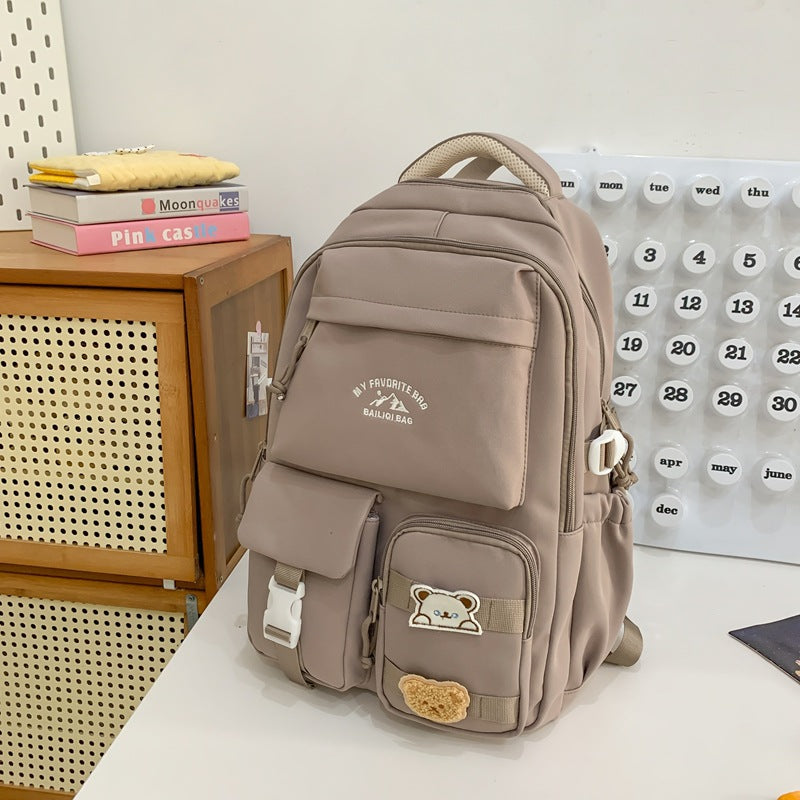 Minimalist korean style fashion casual backpack for high school and college students, featuring cute cartoon badges and large capacity