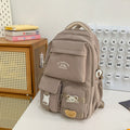 Minimalist korean style fashion casual backpack for high school and college students, featuring cute cartoon badges and large capacity