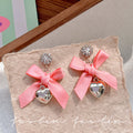 "instagram-worthy, 'rich girl' style pink bow and heart pendant earrings – unique, sweet, and perfect for vacation. wholesale available."