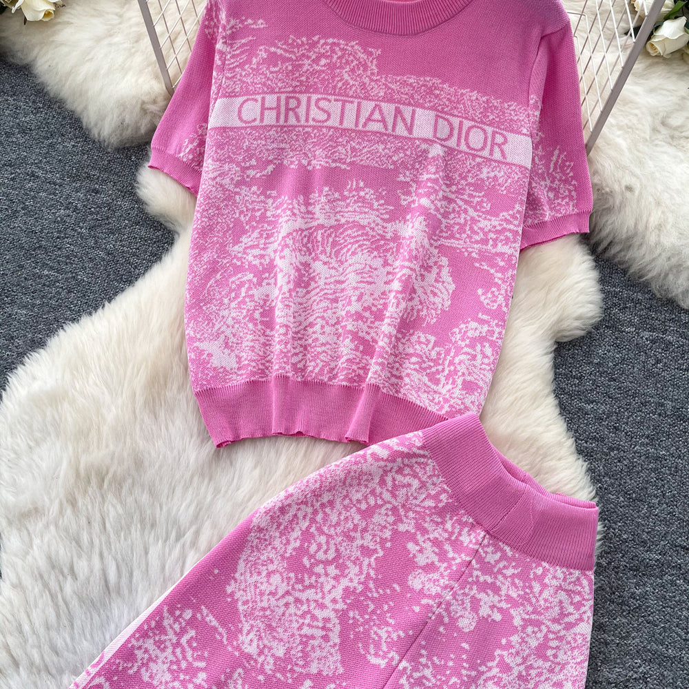 Vacation-ready pink floral print letter print casual two-piece set for women, featuring a summer short-sleeved top and high-waisted wide-leg pants. a stylish and versatile outfit perfect for both work and play