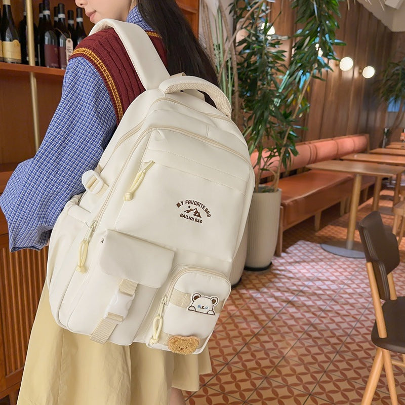 Minimalist korean style fashion casual backpack for high school and college students, featuring cute cartoon badges and large capacity