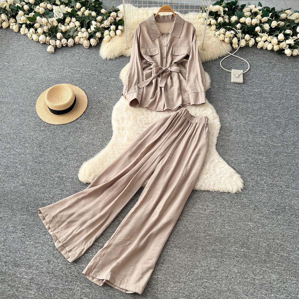 Sophisticated, niche design two-piece set for women: a long-sleeved, tie-waist blouse with a bow detail, paired with high-waisted, wide-leg pants