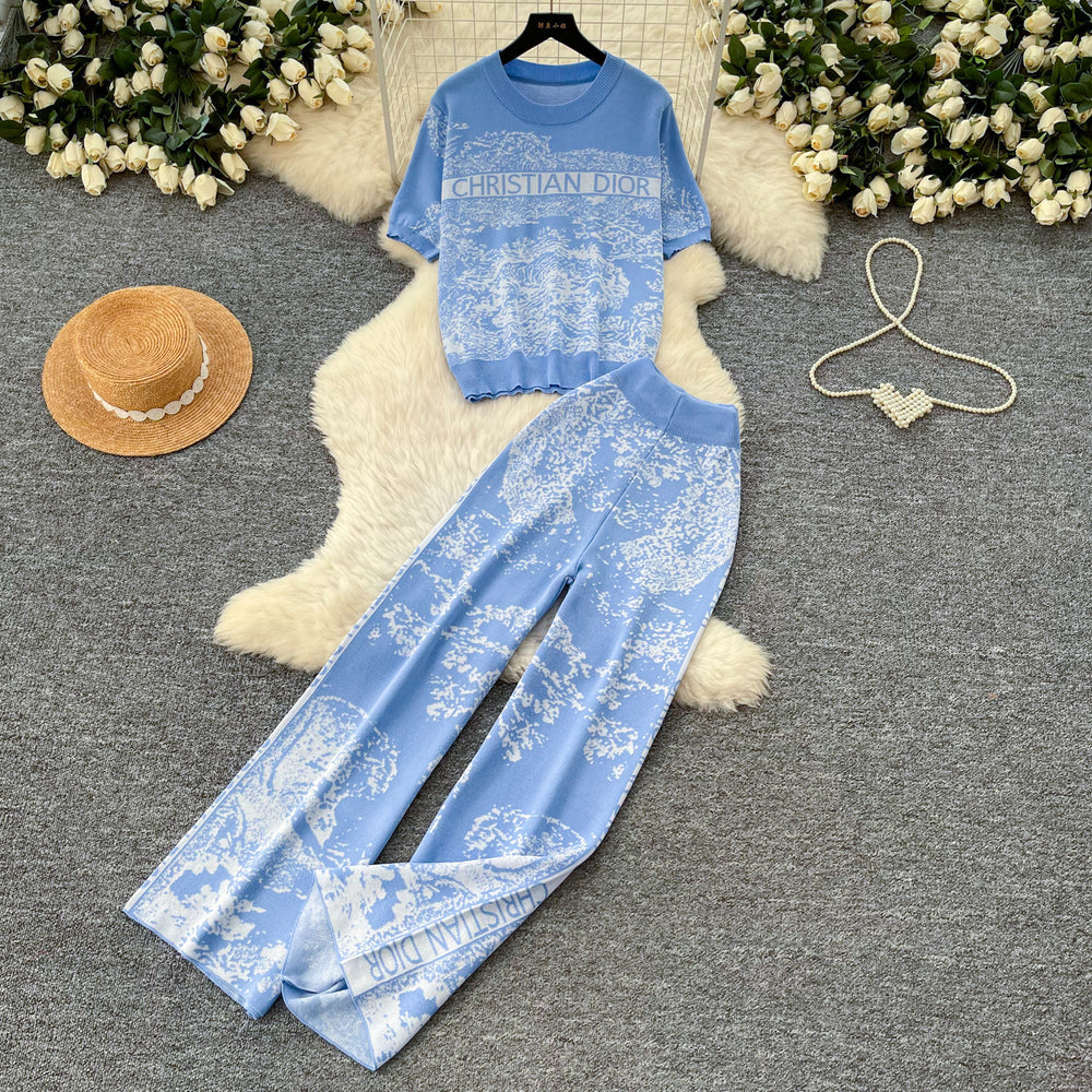 Vacation-ready pink floral print letter print casual two-piece set for women, featuring a summer short-sleeved top and high-waisted wide-leg pants. a stylish and versatile outfit perfect for both work and play