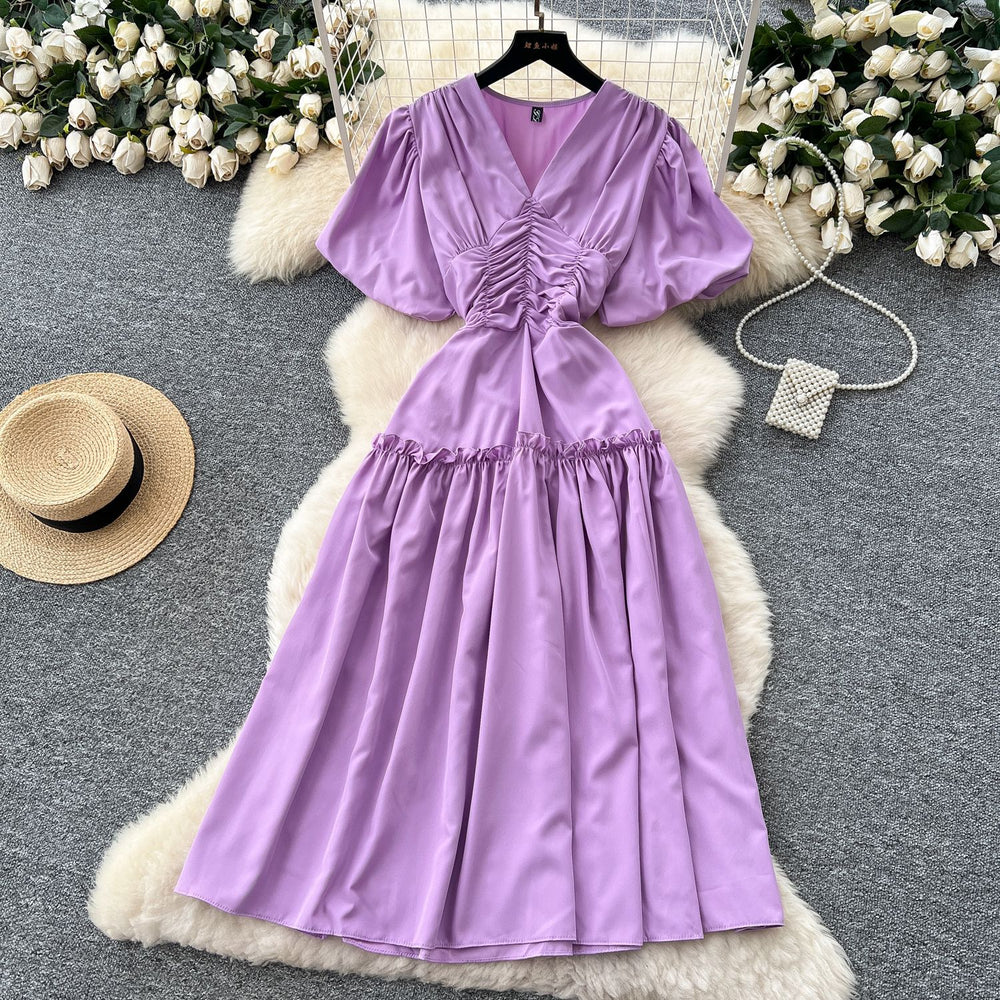 French-inspired, niche v-neck dress with ruched waist, puff sleeves, and a flowy, a-line silhouette. perfect for a slimming and elegant summer look