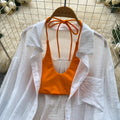 Vacation-ready bikini set for the hot girl summer look: orange cami top, floral print skirt, and sun-protective cardigan – a chic and stylish three-piece outfit