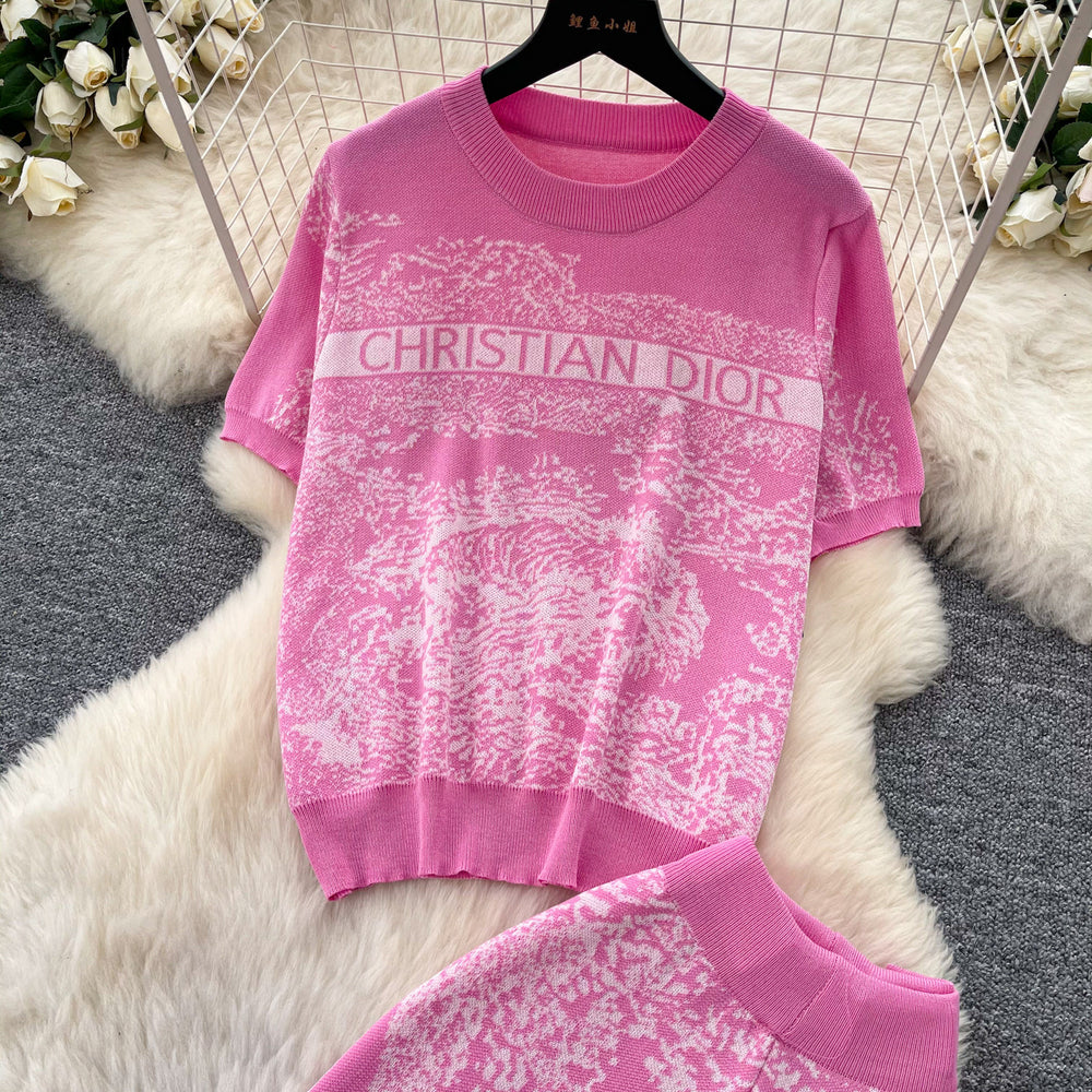 Vacation-ready pink floral print letter print casual two-piece set for women, featuring a summer short-sleeved top and high-waisted wide-leg pants. a stylish and versatile outfit perfect for both work and play