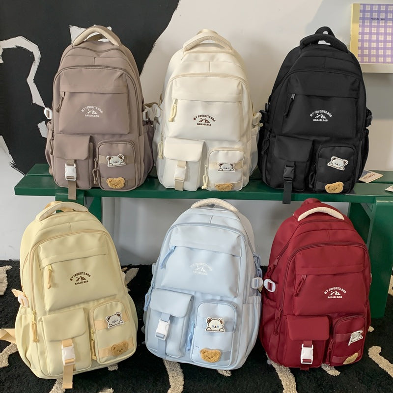 Minimalist korean style fashion casual backpack for high school and college students, featuring cute cartoon badges and large capacity