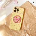 Trendy, custard-yellow iphone 17 case with a full-color heart design and stand. available in contrasting color iphone 18 soft case styles