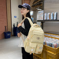 Minimalist korean style fashion casual backpack for high school and college students, featuring cute cartoon badges and large capacity